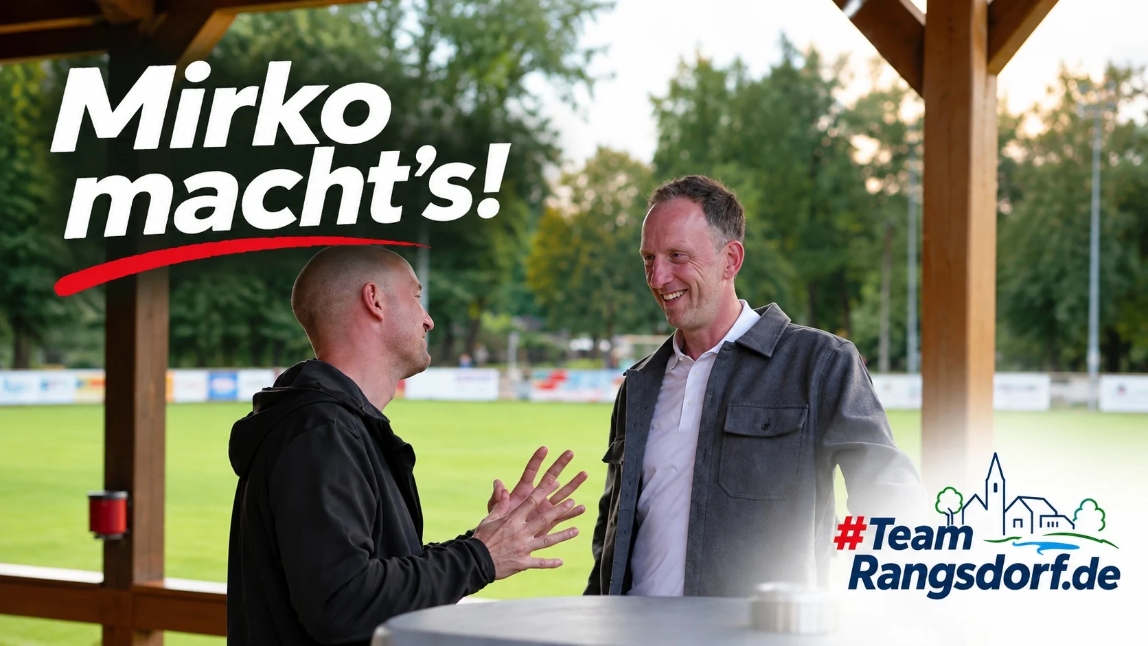 Mirko Sänger hört einem Gesprächspartner am Sportplatz zu